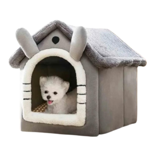 A small white dog blissfully lounges inside the Indoor Plush Soft Dog House, a cozy, grey, plush bed designed to resemble a whimsical cottage.
