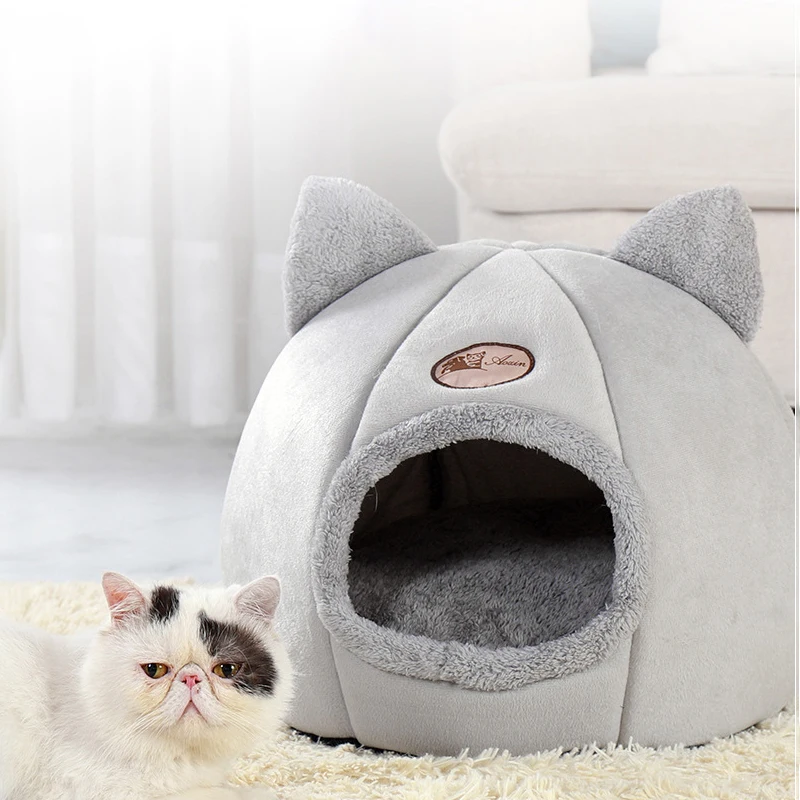 A disgruntled Persian cat lounging next to its grey cat cave bed, giving off a "not amused" vibe while showcasing the bed's design.